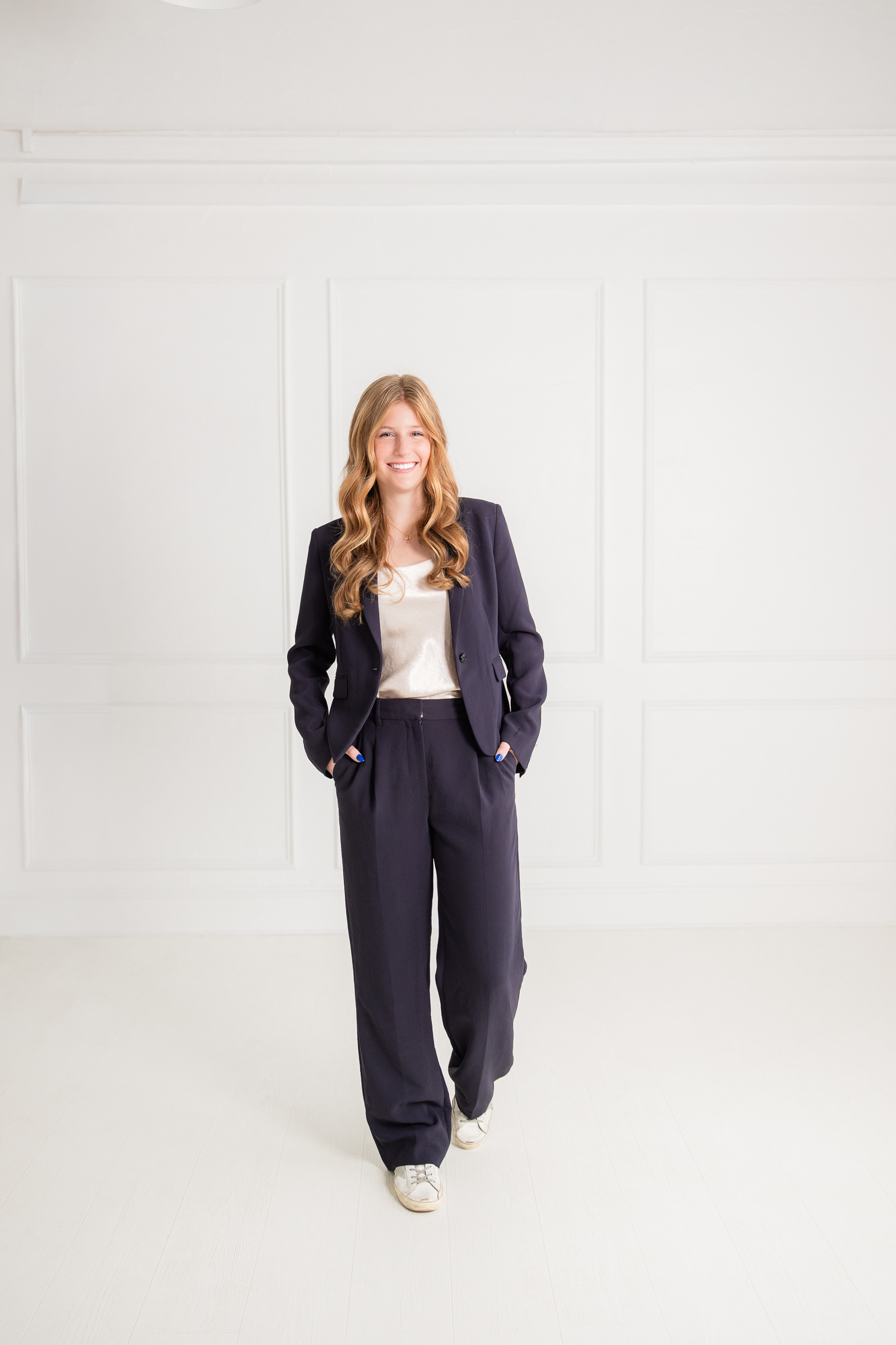 full body portrait of a woman walking confidently in a neutral studio space