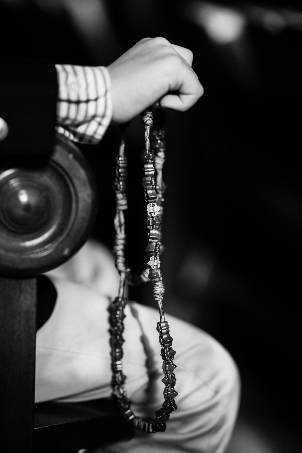 Close-up of a hand holding a rosary in church, captured by a Catholic photographer